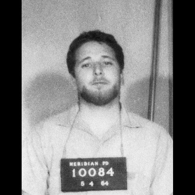 A black and white mug shot of Michael Schwerner
