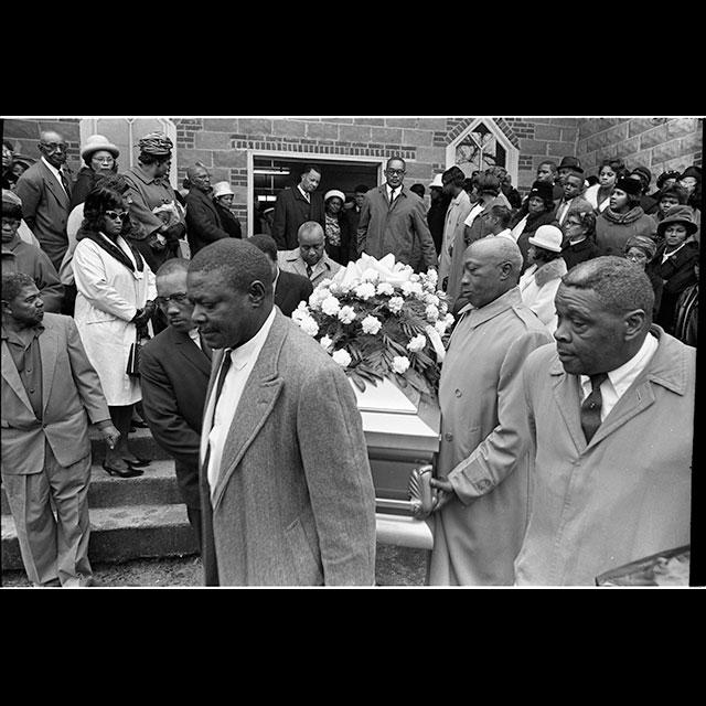 A black and white photograph of pallbearers carrying the casket of Vernon Dahmer from the Shady Grove Baptist Church in the Kelly Settlement on January 15, 1966